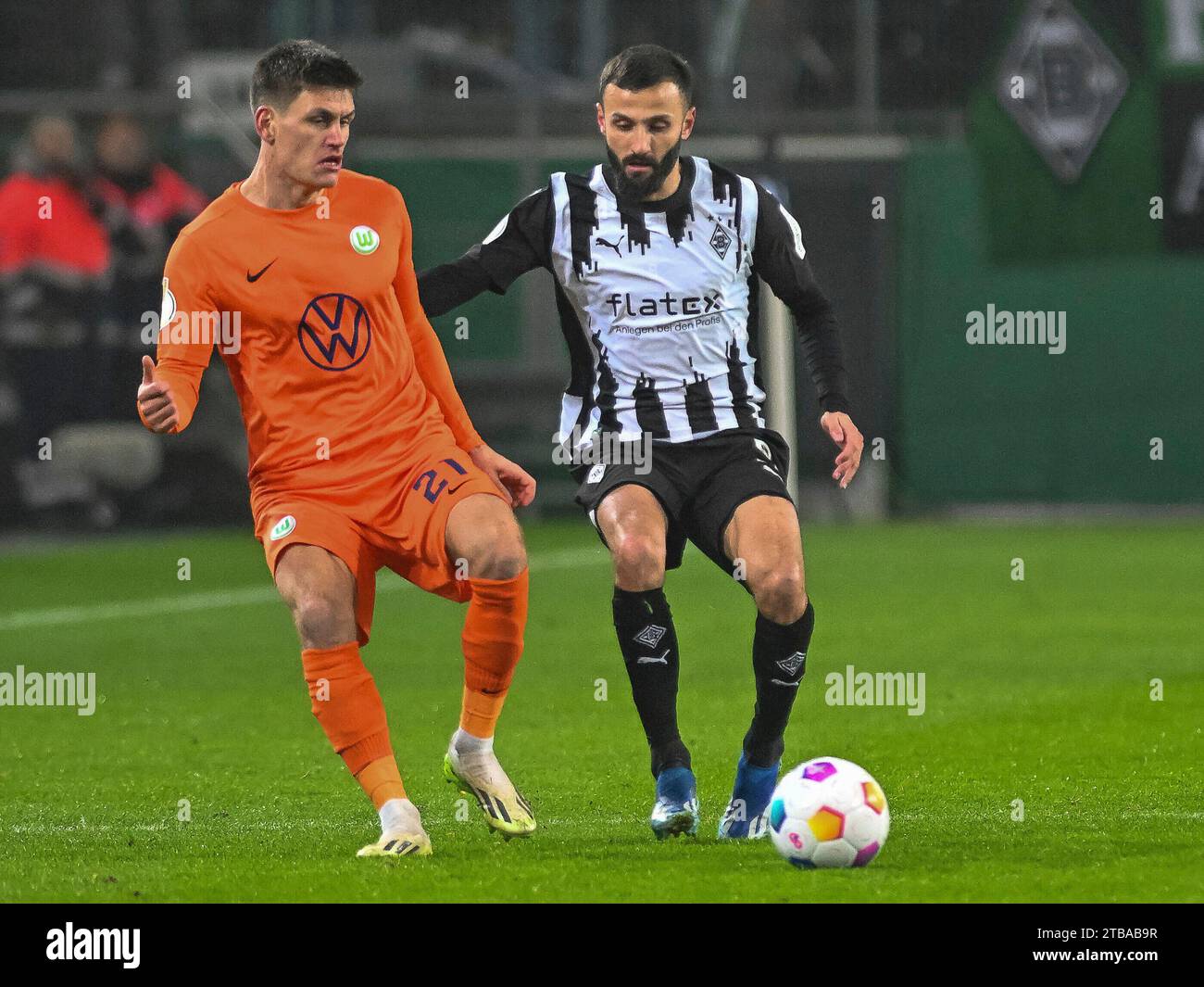 Wieder ein Ball zurueck. Joakim Maehle Pedersen (VFL Wolfsburg, n. 21) wird von Franck Honorat (Borussia Moenchengladbach, n. 09) angelaufen. Borussia Moenchengladbach vs. VfL Wolfsburg, Fussball, DFB-Pokal, Achtelfinale, Saison 2023/2024, 05.12.2023 le normative DFB/DFL vietano qualsiasi uso di fotografie come sequenze di immagini e/o quasi-video foto: Eibner-Pressefoto/Thomas Haesler Foto Stock