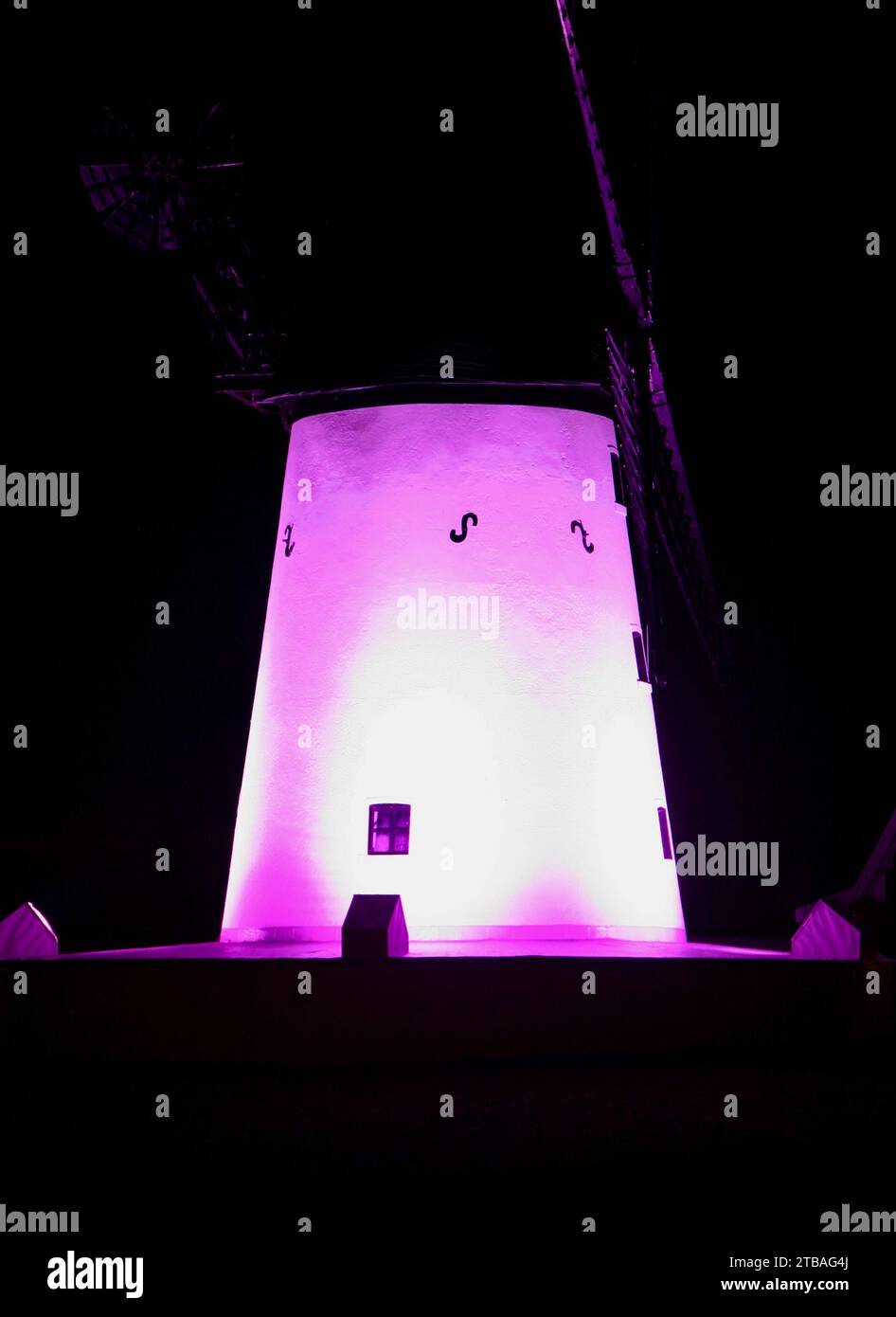 Una vista del famoso mulino a vento di Lytham St Annes, Lancashire, Regno Unito, Europa in una fredda notte d'inverno, illuminato da una macabra luce viola Foto Stock