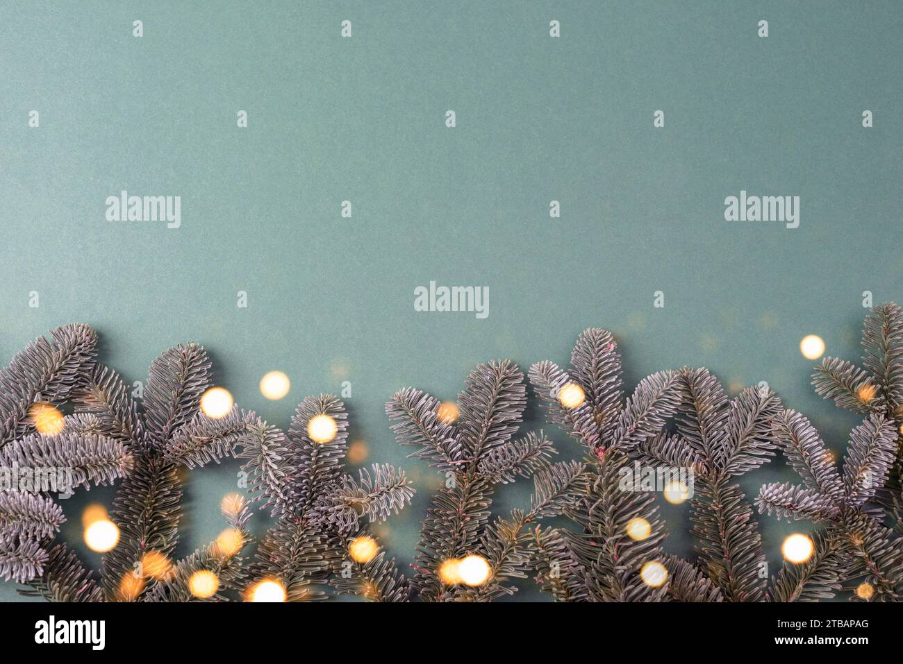 Sfondo natalizio con rami di abete e luci bokeh. Vista dall'alto, base piatta, spazio di copia. Foto Stock
