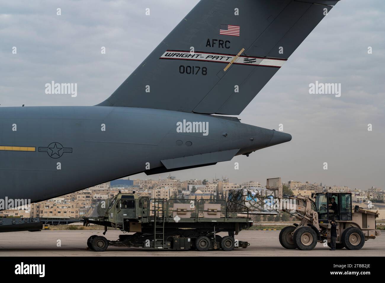 U.S. Air Force Airmen e U.S. Agency for International Development Personnel caricano un C-17 Globemaster III in un campo di aviazione non divulgato in Medio Oriente, 5 dicembre 2023. Il governo degli Stati Uniti collabora con il programma alimentare Mondiale delle Nazioni Unite (WFP) e l'Agenzia delle Nazioni Unite per il soccorso e l'occupazione dei rifugiati palestinesi nel vicino Oriente (UNRWA). (Foto U.S. Air Force del sergente dello staff Daniel Hernandez) Foto Stock