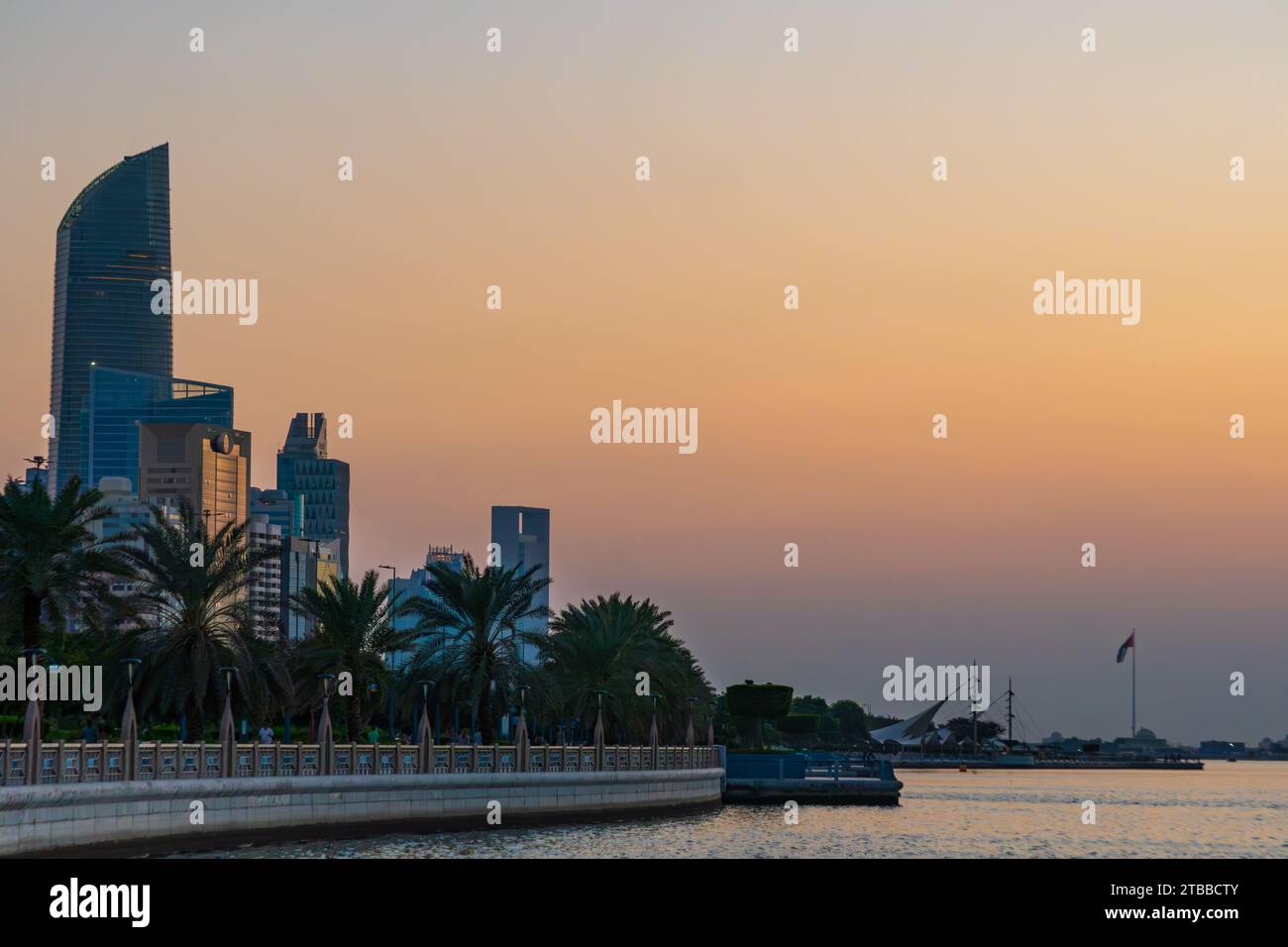 La Corniche di Abu Dhabi al tramonto, grattacieli in lontananza, Emirati Arabi Uniti. Blue Hour, edifici moderni, mare persiano. Foto Stock