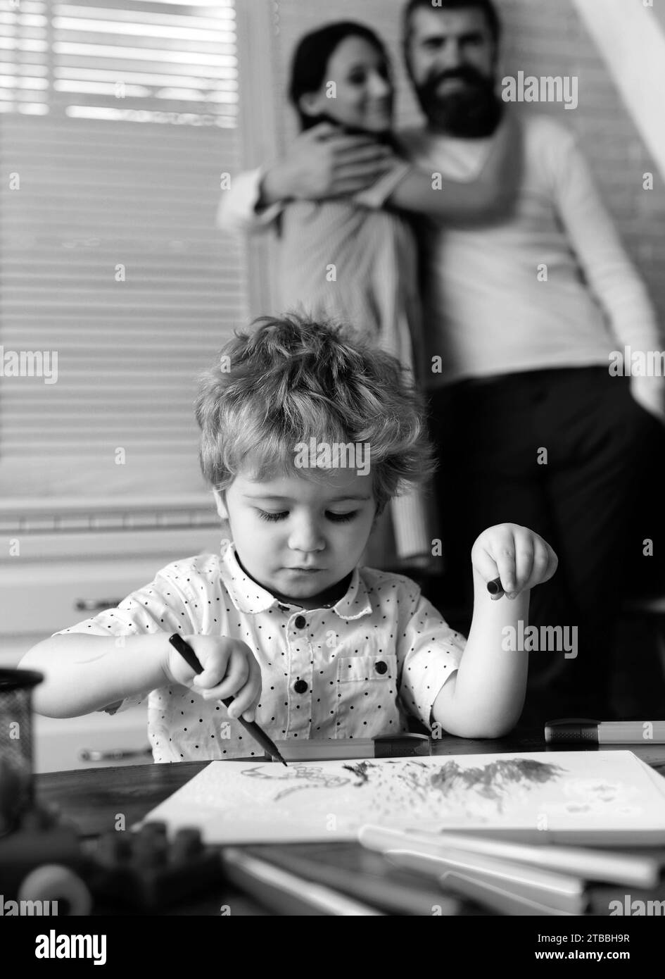 Figlio bambino con padre e madre che disegnano a casa. Vacanze in famiglia e insieme. Mamma, papà e bambino, vacanze e insieme. Bambini all'inizio dell'arte A. Foto Stock