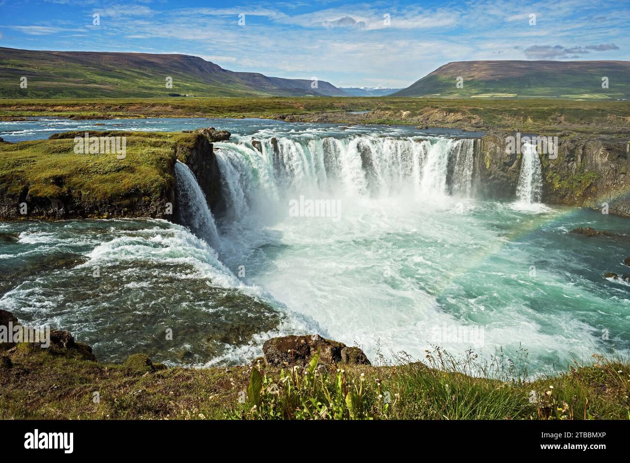 Il fiume Skjalfandafljot si schianta sopra la cascata di Godafoss nell'Islanda settentrionale con un cielo parzialmente nuvoloso sullo sfondo Foto Stock