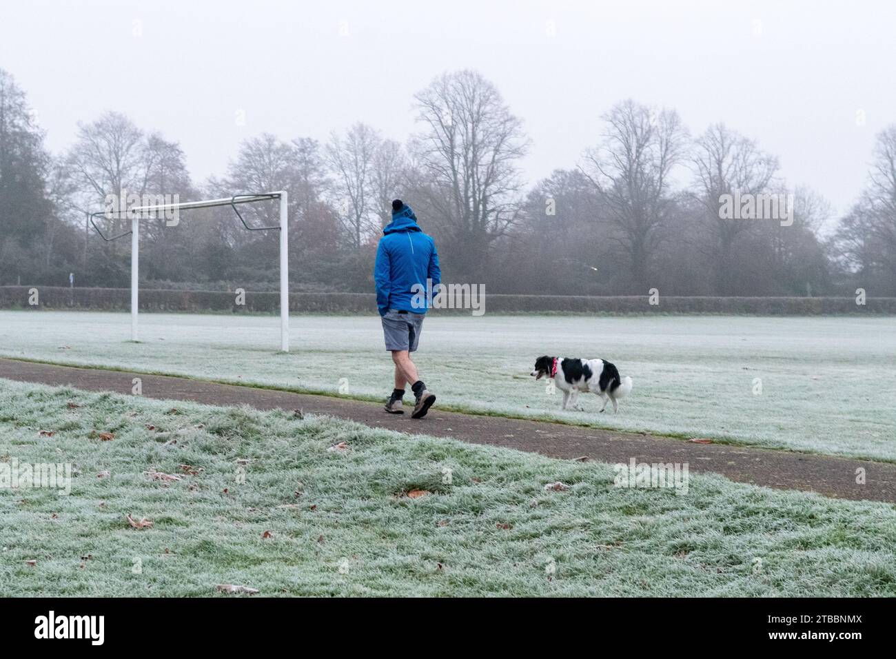 Fordingbridge, New Forest, Hampshire, Regno Unito, 6 dicembre 2023: Meteo. Nebbia mattutina e gelo nei parchi e nei campi da gioco nelle zone basse vicino al fiume Avon. Uomo che cammina un cane. Crediti: Paul Biggins/Alamy Live News Foto Stock