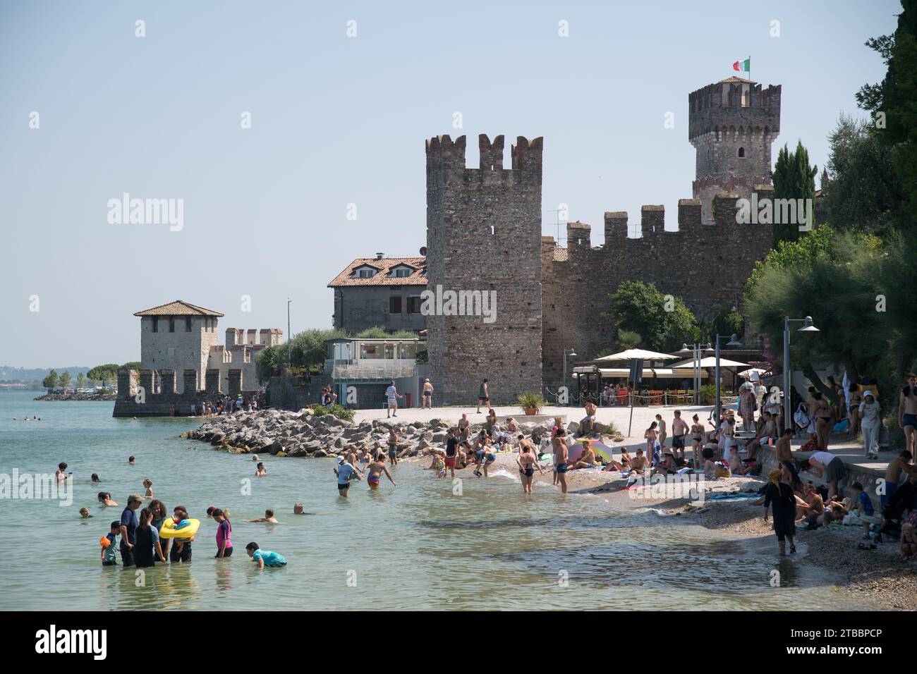 Spiaggia del prete e castello gotico scaligero di Sirmione, porto fortificato del XIV secolo dal Lago di Gard Foto Stock