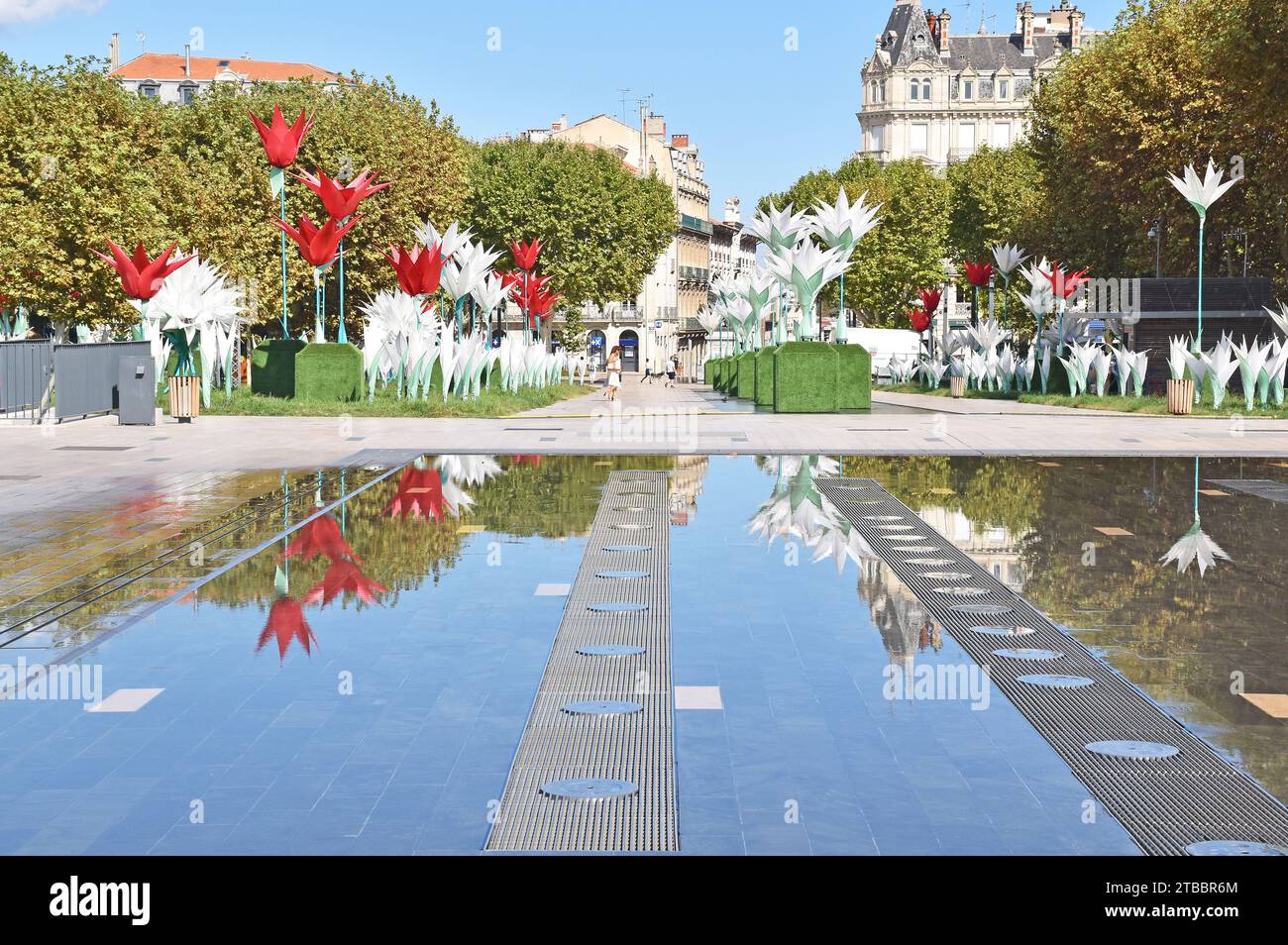 Place Jean Jaures, uno spazio pubblico all'aperto nel centro di Béziers, Francia, con fontane moderne, enormi sculture floreali e stand di alberi di aerei Foto Stock