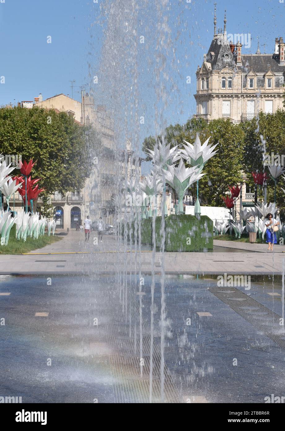 Place Jean Jaures, uno spazio pubblico all'aperto nel centro di Béziers, Francia, con fontane moderne, enormi sculture floreali e stand di alberi di aerei Foto Stock