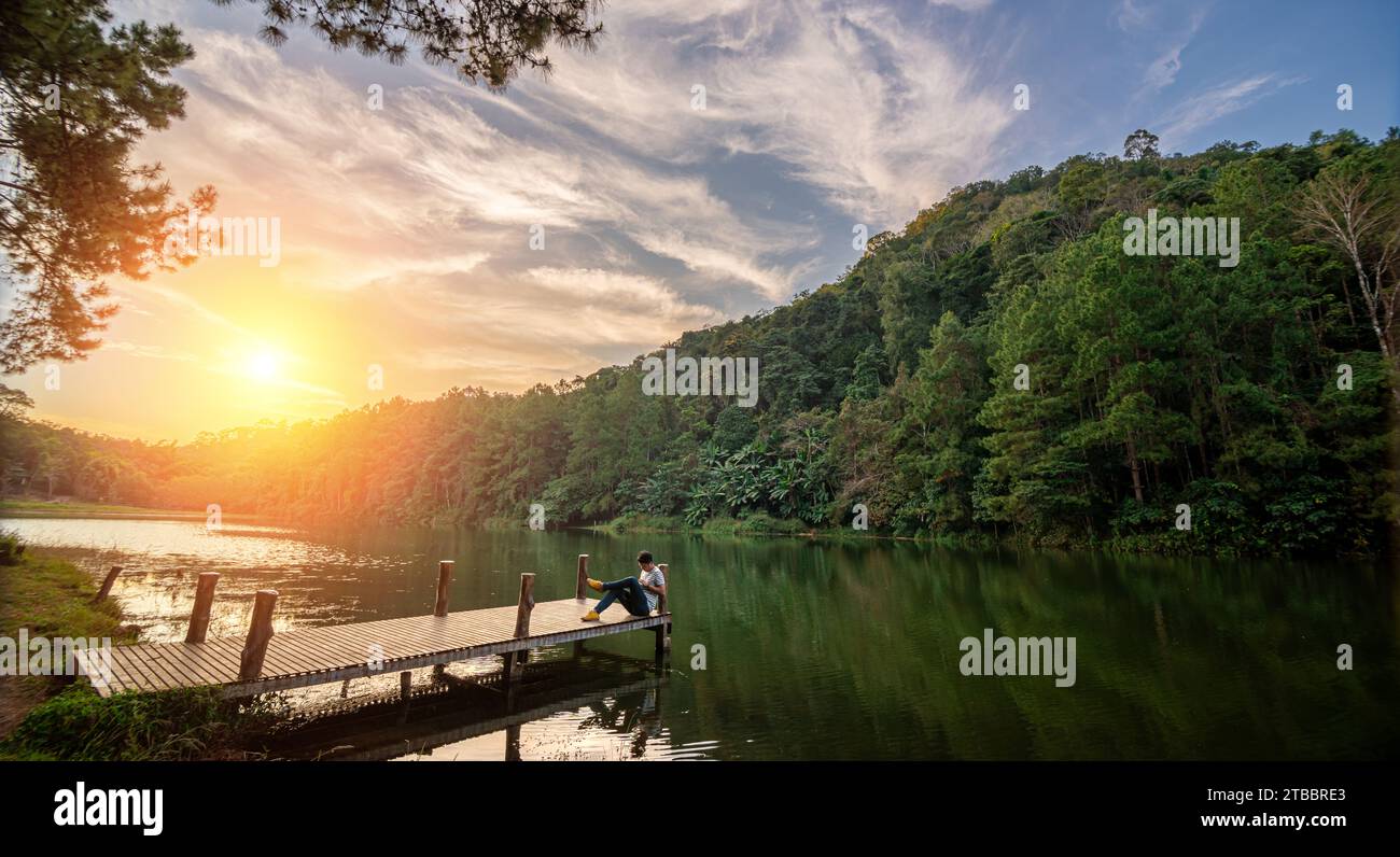 Il viaggiatore con tablet è rilassarsi nel Lago Pang Ung, nel Nord della Thailandia. Si tratta di un'attrazione turistica che la gente viene a visitare per le vacanze invernali Foto Stock