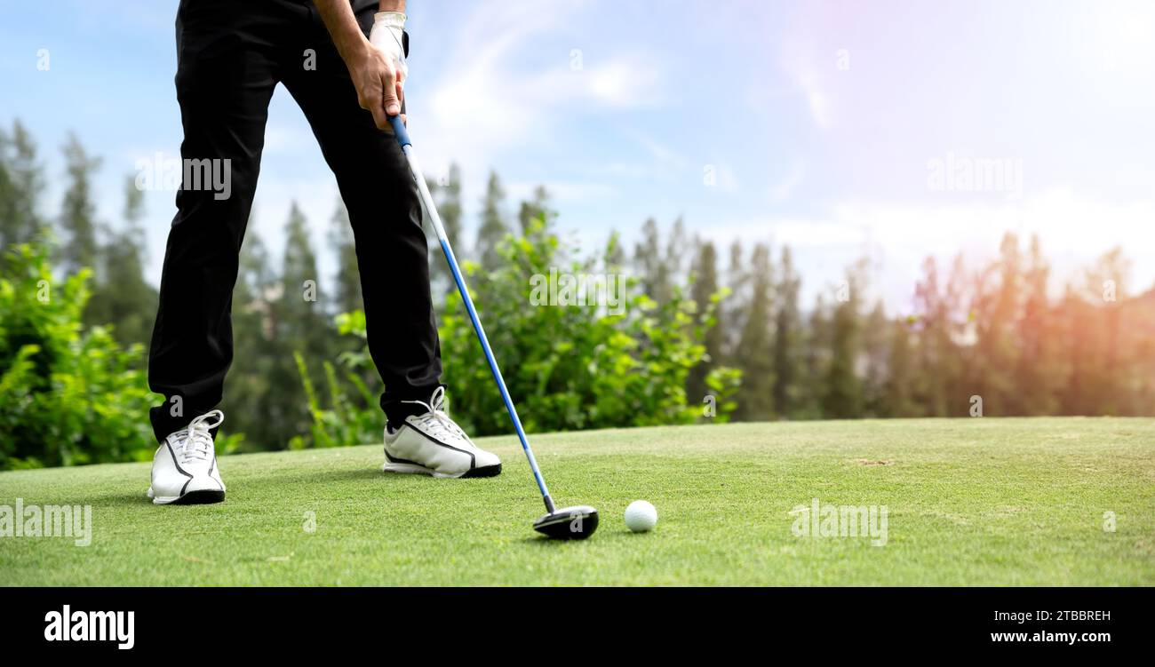 Golfista maschile che gioca a golf sul campo da golf. Il golfista utilizza un driver per colpire una palla da golf dal fairway. Foto Stock