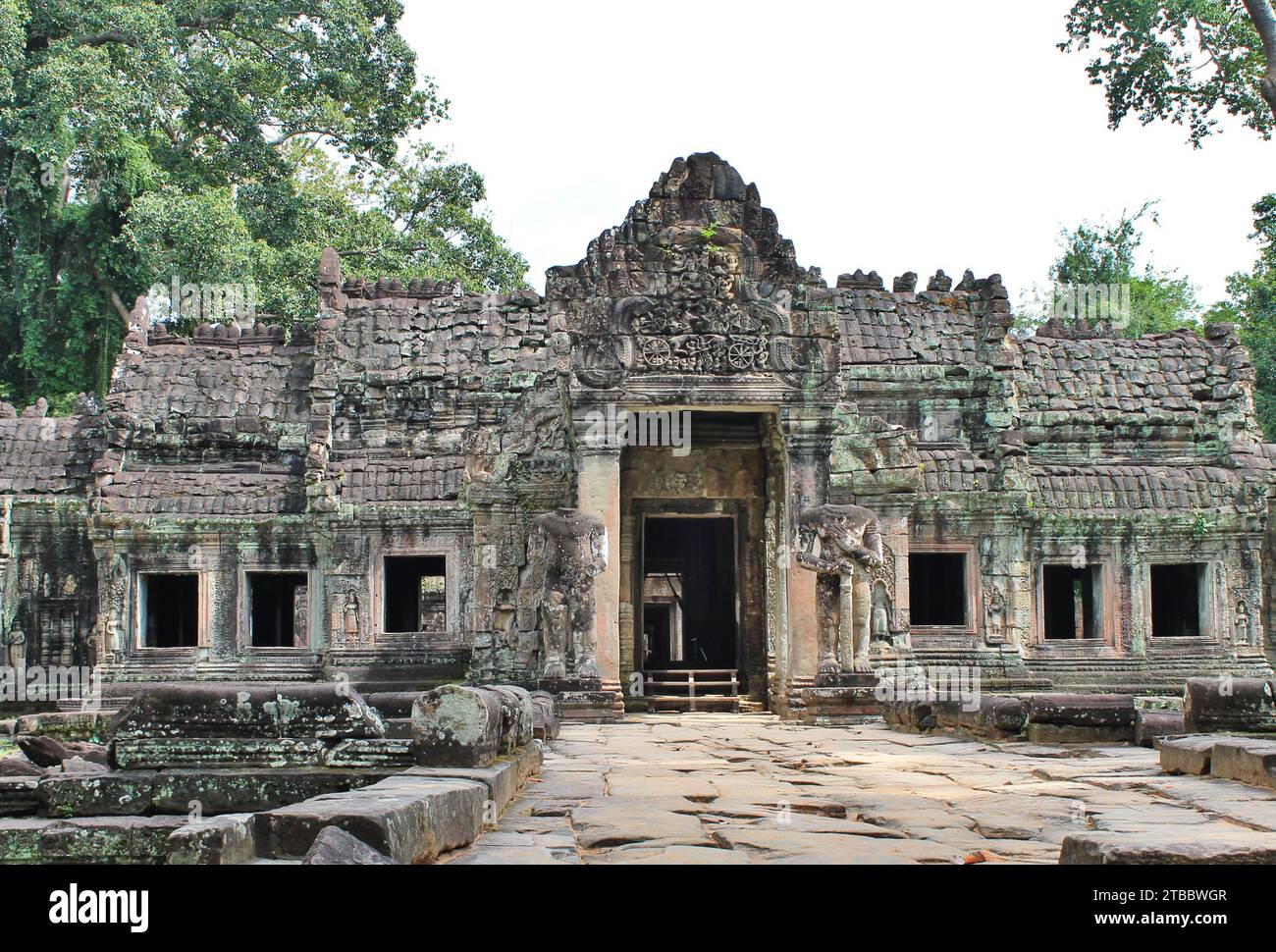 Una tipica struttura di templi in pietra nel Parco Archeologico di Angkor, Cambogia. Alle figure in piedi accanto alla porta mancano la testa Foto Stock