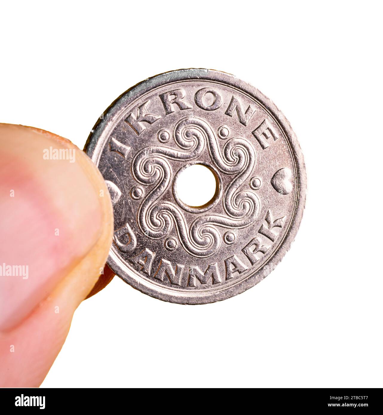 Una moneta di corona danese tra le dita della mano con uno sfondo trasparente Foto Stock