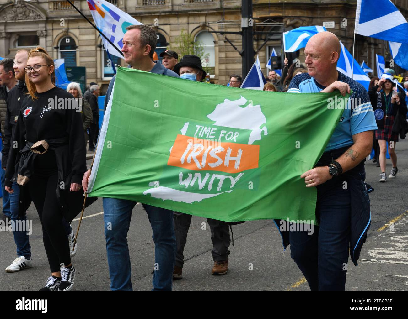 Due uomini hanno una bandiera che dice "tempo per l'unità irlandese" durante una marcia per l'indipendenza scozzese a Glasgow, in Scozia Foto Stock