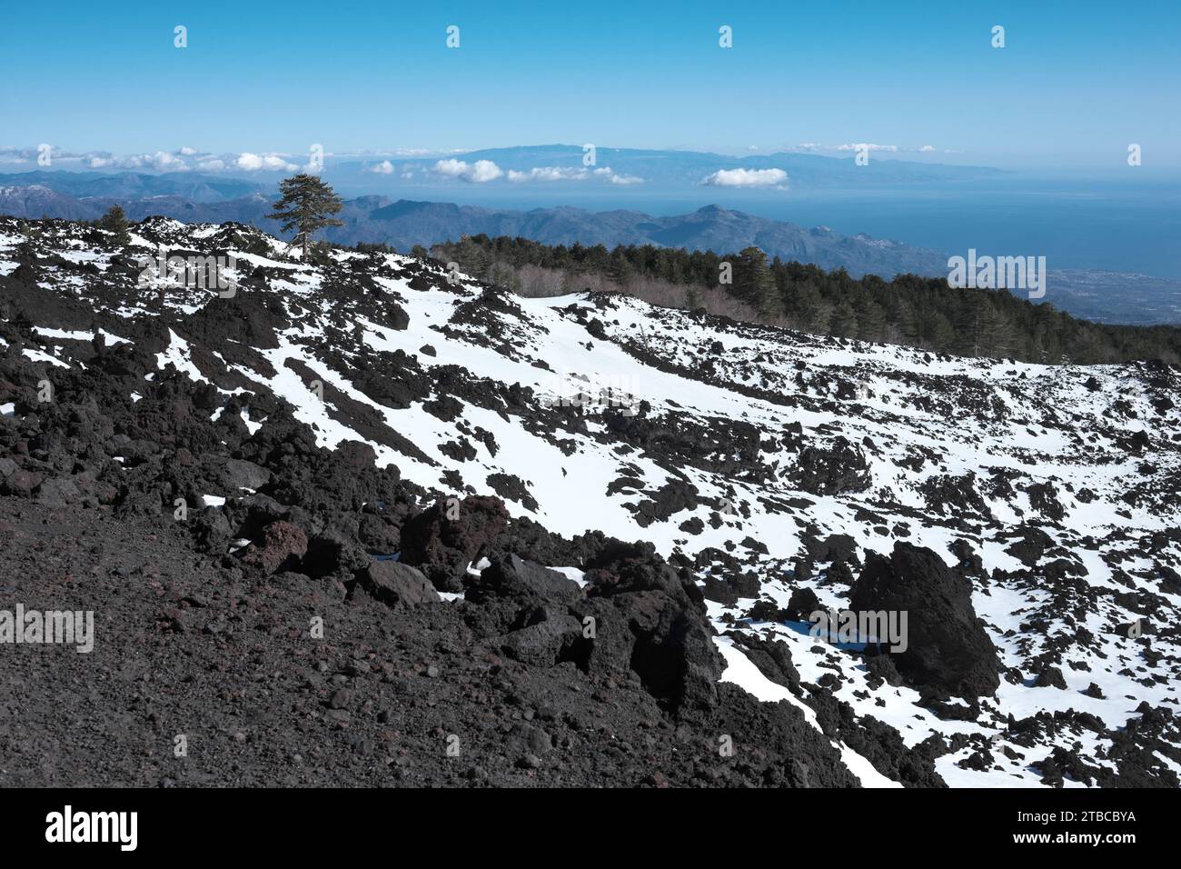 Roccia vulcanica innevata di lava antica dal sentiero al cratere nord-orientale dell'Etna, piano Provenzana, Sicilia, Italia Foto Stock