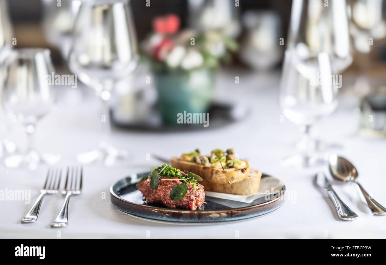 Tartare di bistecca con pane tostato servito su un tavolo del ristorante. Foto Stock