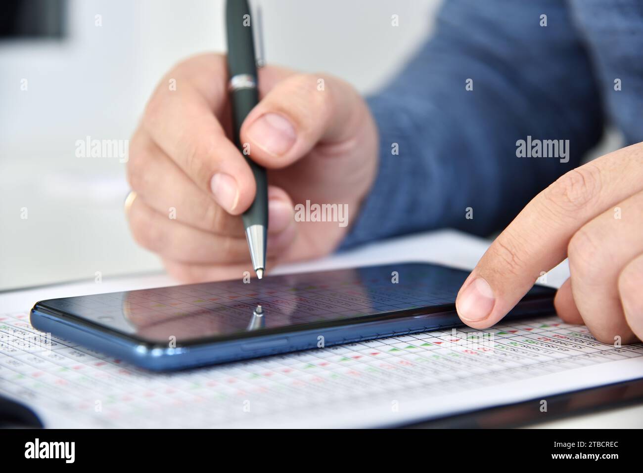 L'uomo d'affari regola le statistiche aziendali sullo smartphone a schermo. Concetto di statistiche sulle negoziazioni e sulle azioni su Internet. Primo piano Foto Stock