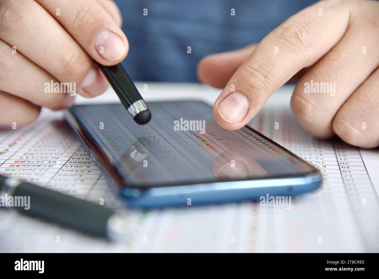 Un uomo d'affari utilizza uno smartphone con statistiche aziendali sullo schermo. Business concept e trading su Internet. Primo piano Foto Stock