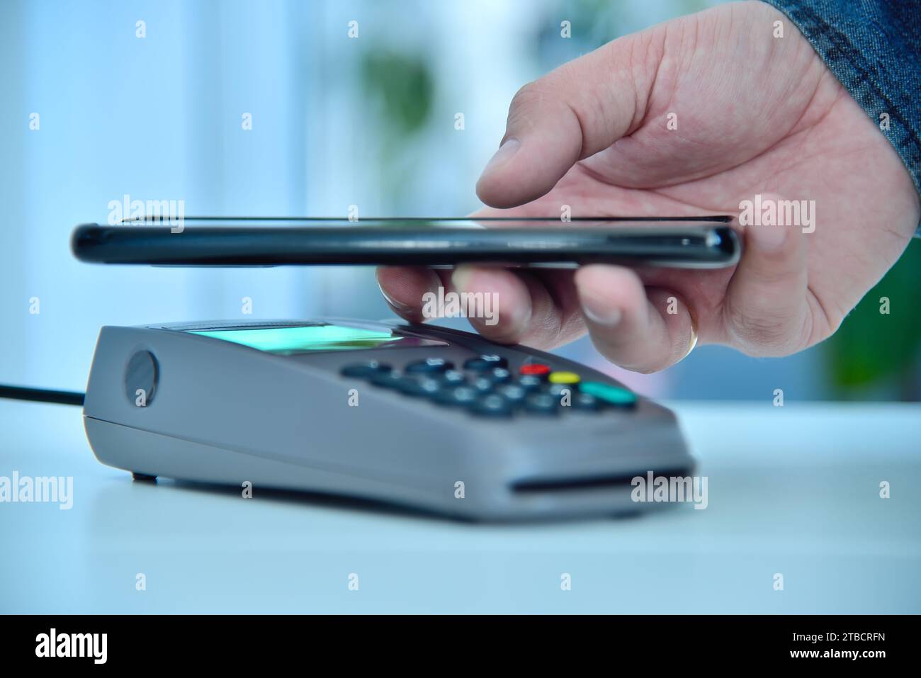 Telefono portatile con pagamento sul terminale Pay pass pos. Concetto di pagamento mobile e shopping online. Primo piano Foto Stock