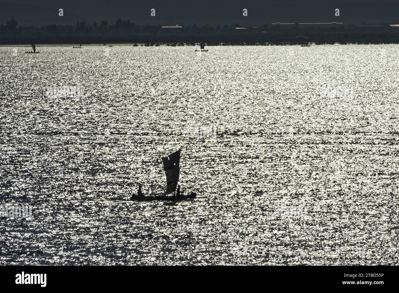 Dhow tradizionale, barca a vela, barca da pesca, retroilluminazione, acqua scintillante, silhouette, Toliara, Madagascar Foto Stock