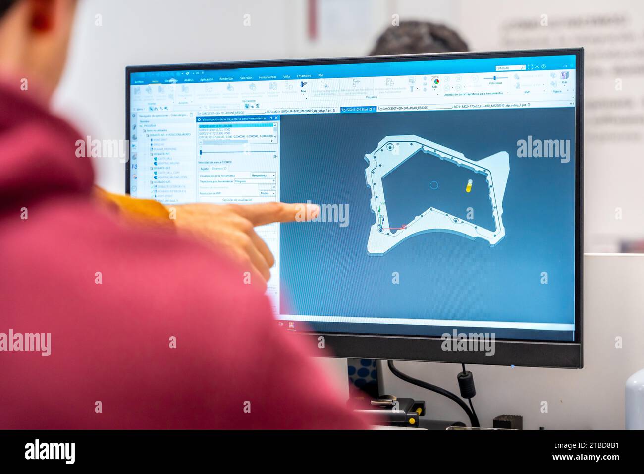 Ingegneri che progettano un pezzo di metallo in un computer nell'ufficio di una moderna fabbrica cnc Foto Stock