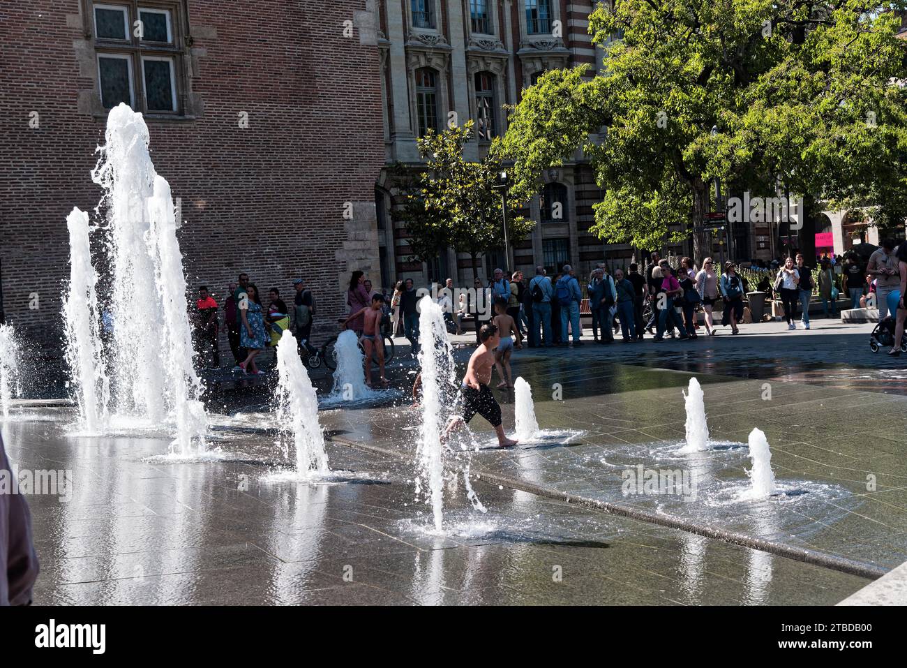 enfants jouant avec des jets d'eau par une belle et chaude journée d'été à Toulouse - bambini che giocano con getti d'acqua in una calda giornata estiva Foto Stock