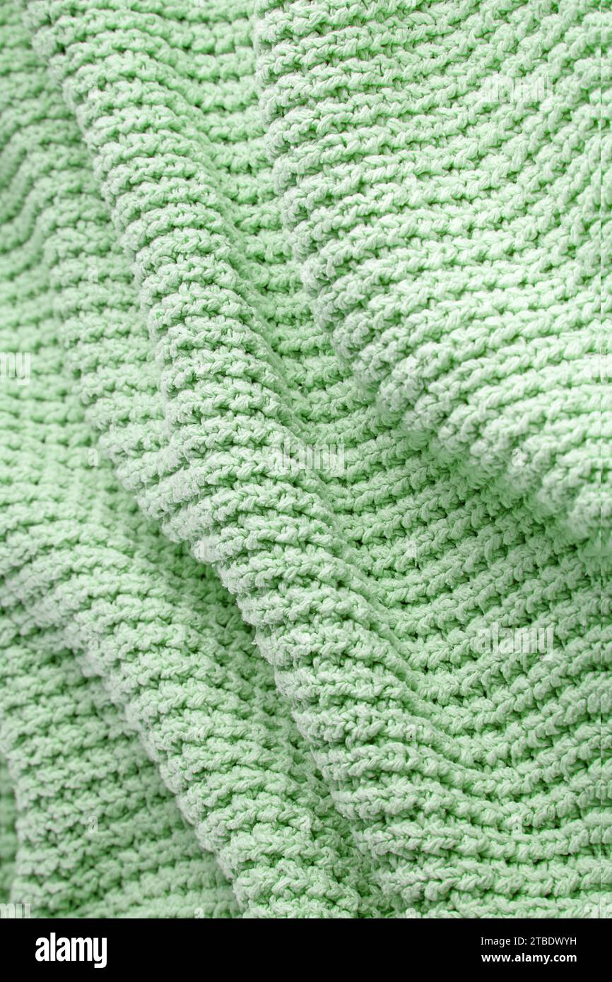 Coperta verde turchese in maglia grossa con pieghe. Sfondo per la progettazione. Foto Stock