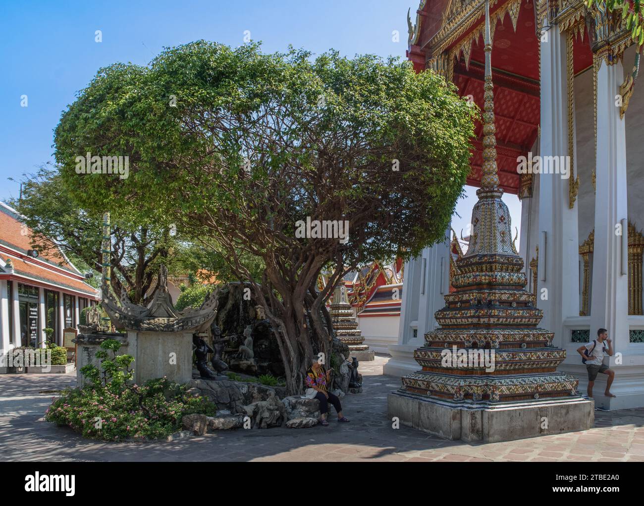 Bangkok, Thailandia - 19 marzo 2018: Turisti vicino ad un piccolo giardino con statue e chedis conosciuto come Phra Chedi Rai a Wat Pho. Foto Stock