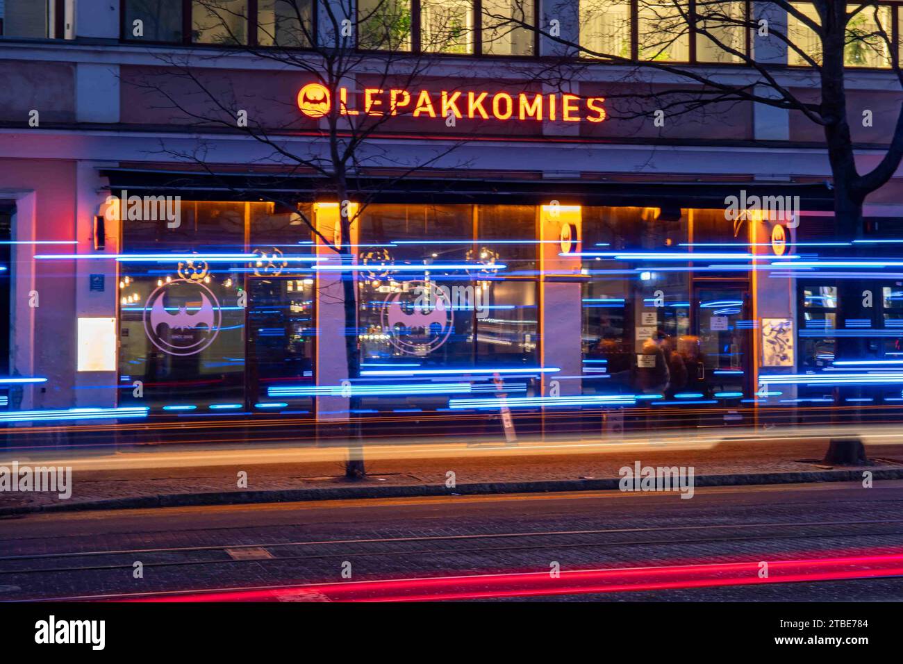 Lepakkomies dive bar e luogo di musica dopo il tramonto con strisce luminose di veicoli di emergenza nel quartiere Harju di Helsinki, Finlandia Foto Stock