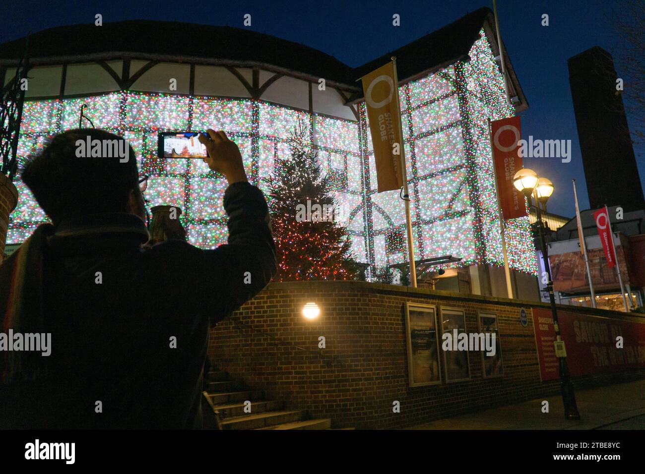 Meteo del Regno Unito, 6 dicembre, Londra: Al crepuscolo in una giornata fredda ma limpida, il Globe Theatre di Shakespeare mette in mostra le luci delle fate mutevoli, con la torre di Tate Modern vista sullo sfondo contro un cielo crepuscolo. Crediti: Anna Watson/Alamy Live News Foto Stock