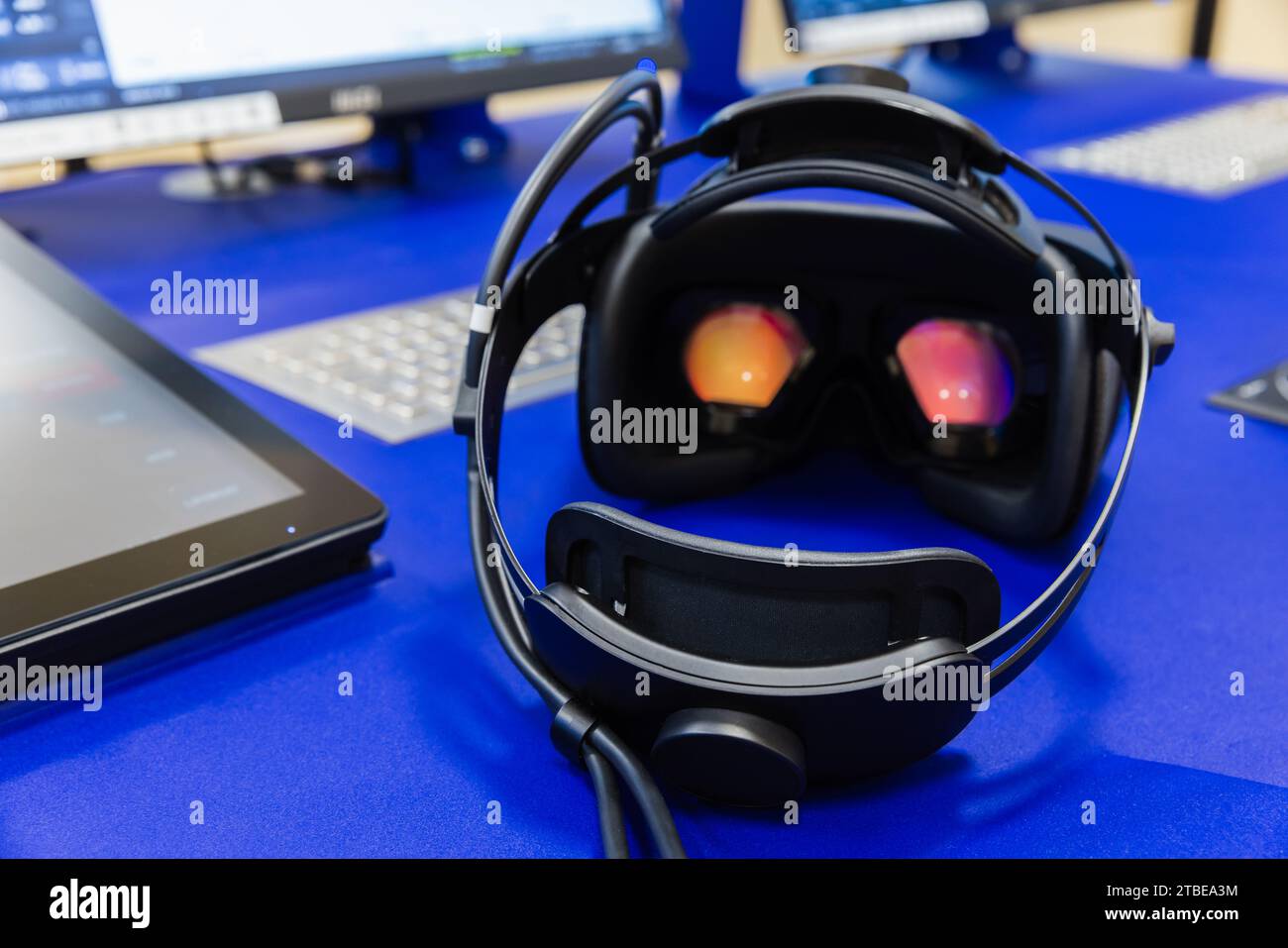 Il visore VR si posiziona sulla scrivania blu, sulla vista posteriore, sulla foto ravvicinata con messa a fuoco selettiva Foto Stock