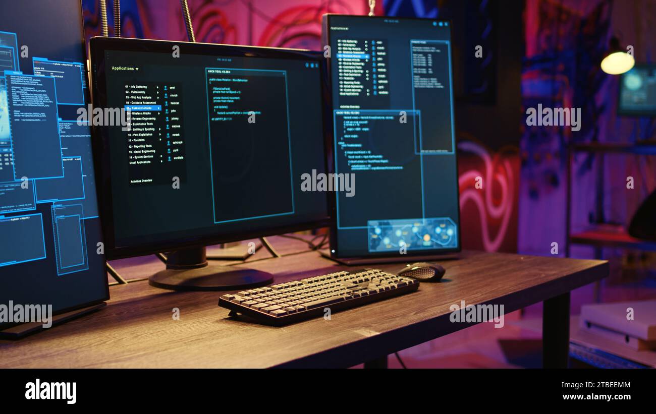 Seminterrato vuoto illuminato al neon con disegni graffiti sulle pareti e computer con tecnologia avanzata lasciavano aperto il codice di esecuzione. Magazzino sotterraneo usato come paradiso del crimine dagli hacker Foto Stock