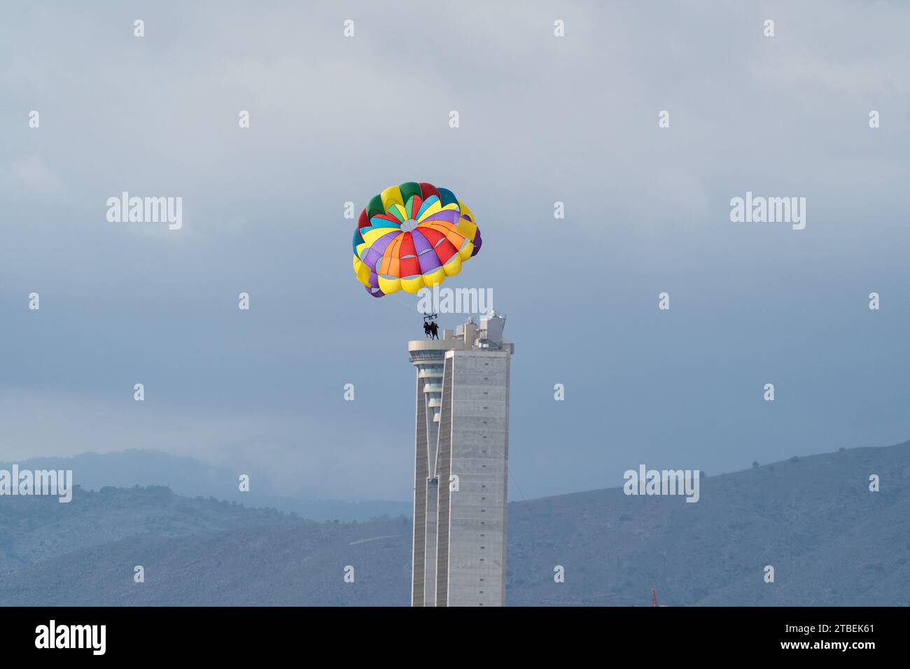 Illusione aerea: Catturata da un'angolazione unica, la mongolfiera sembra atterrare sull'iconico edificio intempo di Benidorm, creando una visuale sorprendente. Foto Stock