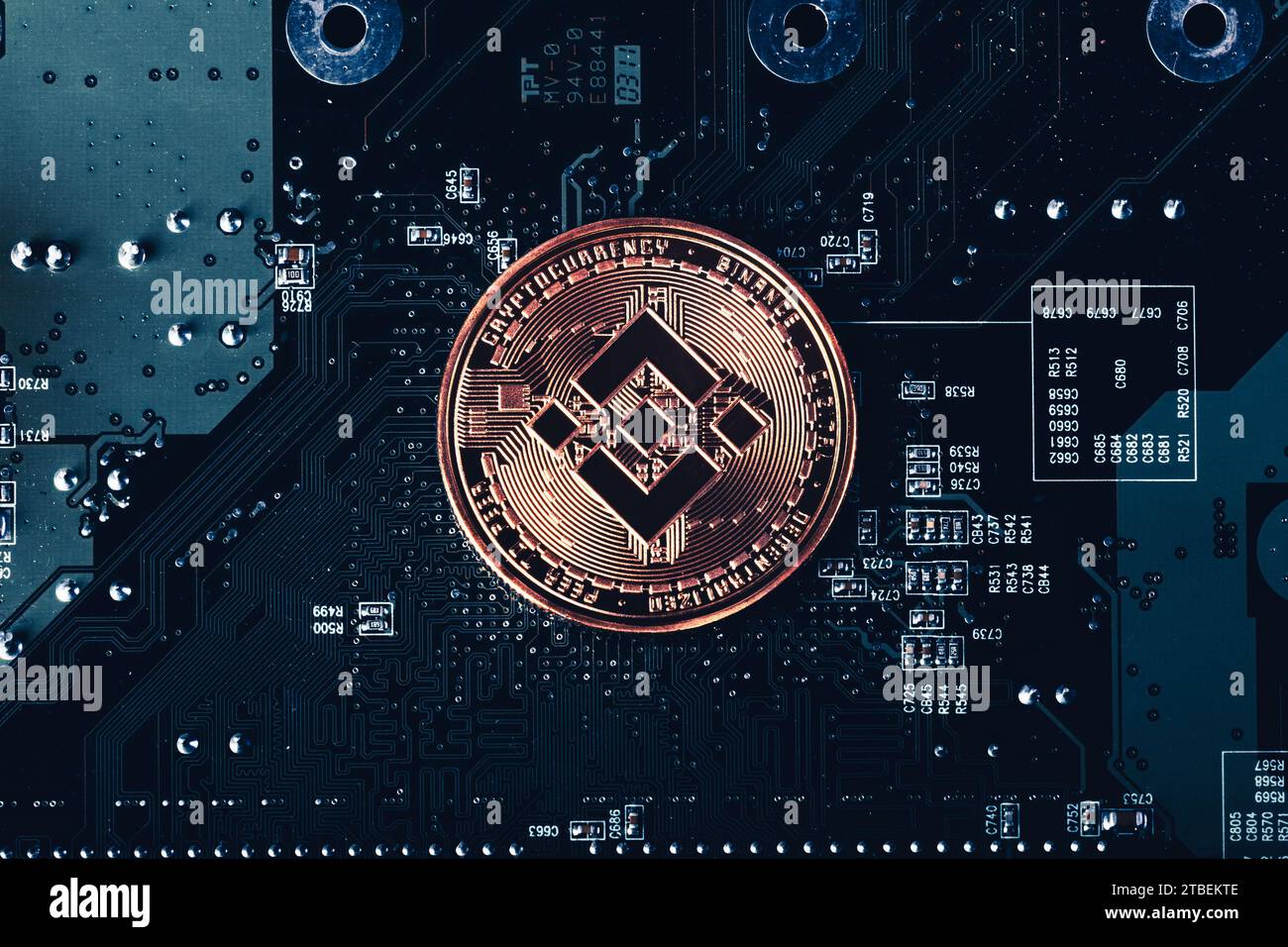 Moneta token di criptovaluta BNB Binance sullo sfondo della scheda a circuiti stampati Foto Stock
