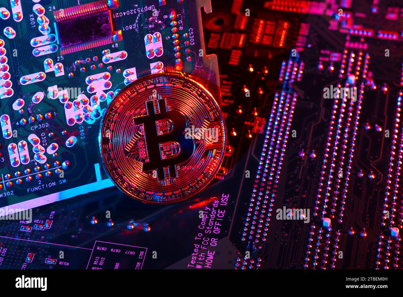 Gettone di criptovaluta Bitcoin contro lo sfondo della scheda a circuito stampato Foto Stock