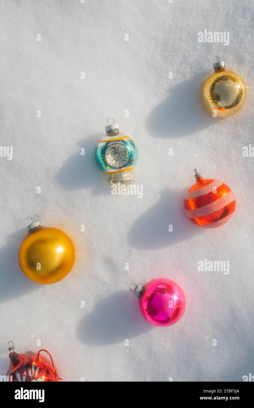 coloratissimi ornamenti in vetro d'epoca color pastello per alberi di natale che si stendono sulla neve Foto Stock