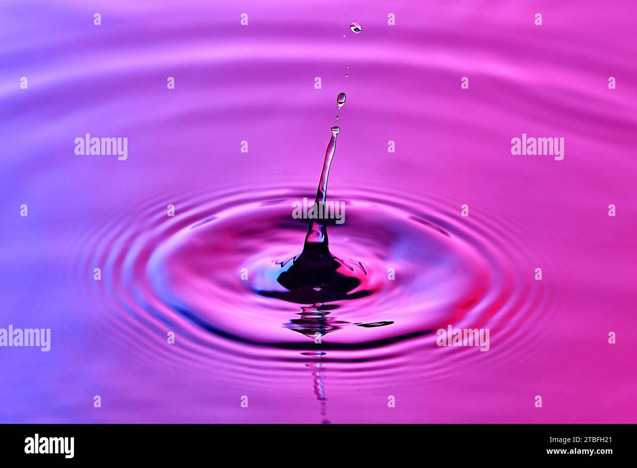 una goccia d'acqua che cade nell'acqua e crea onde Foto Stock