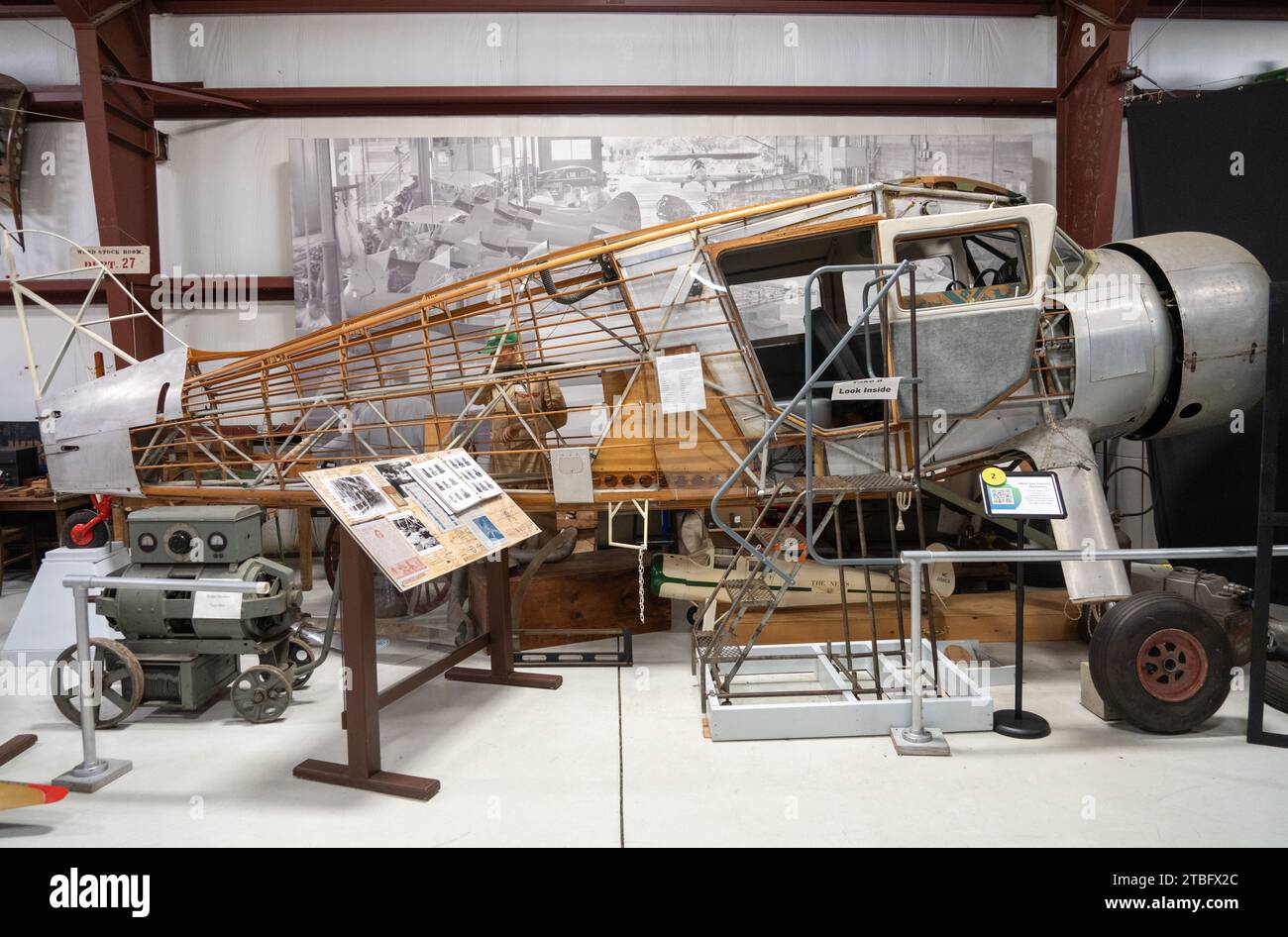 Un fuscellare di aereo parzialmente scheletrico con struttura in legno esposta e una copertura del motore argentata è esposto su un supporto espositivo in un hangar museale in Ohio. Foto Stock