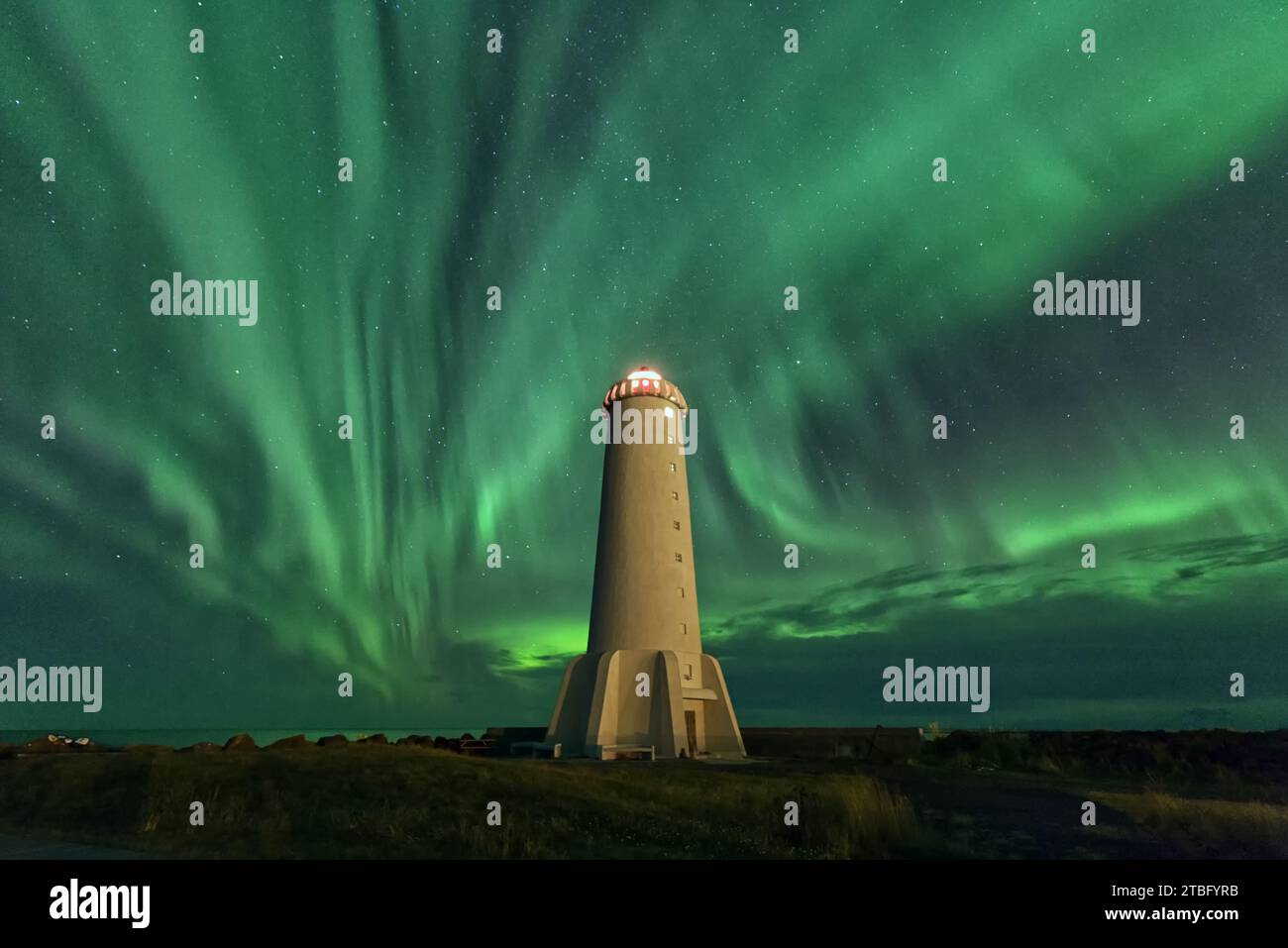 L'aurora boreale sopra un faro, Islanda Foto Stock