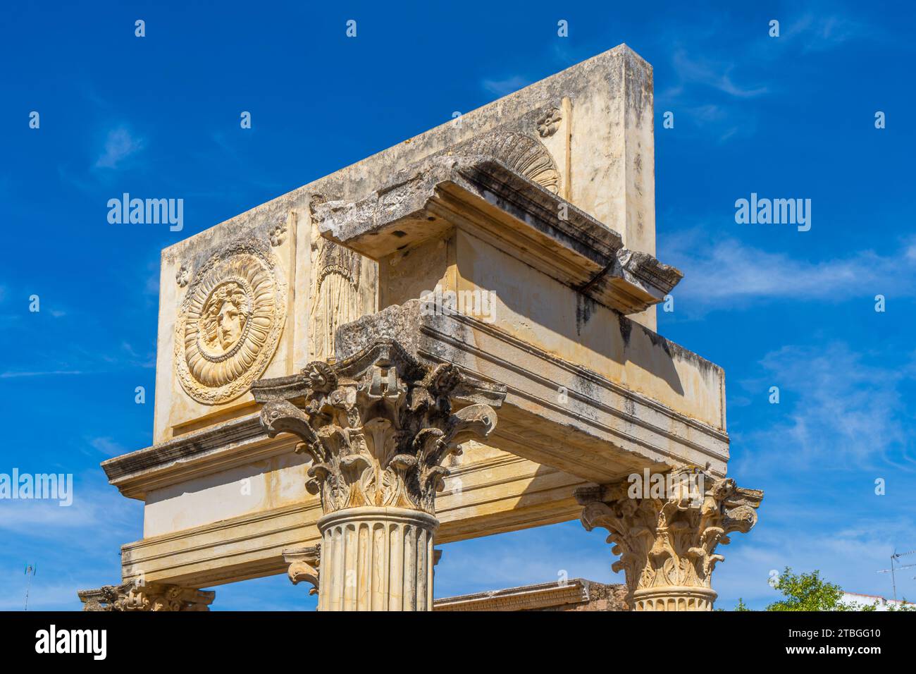 Parte superiore del portico monumentale con mansarda con metopi dell'antico foro Comunale di Augusta Emerita a Merida, con due medaglioni con la hea Foto Stock