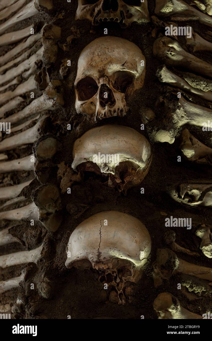 Teschi umani uno sopra l'altro con ossa ai lati che creano un design macabro come copertina di un album di musica pesante della Chapel of Bones Foto Stock