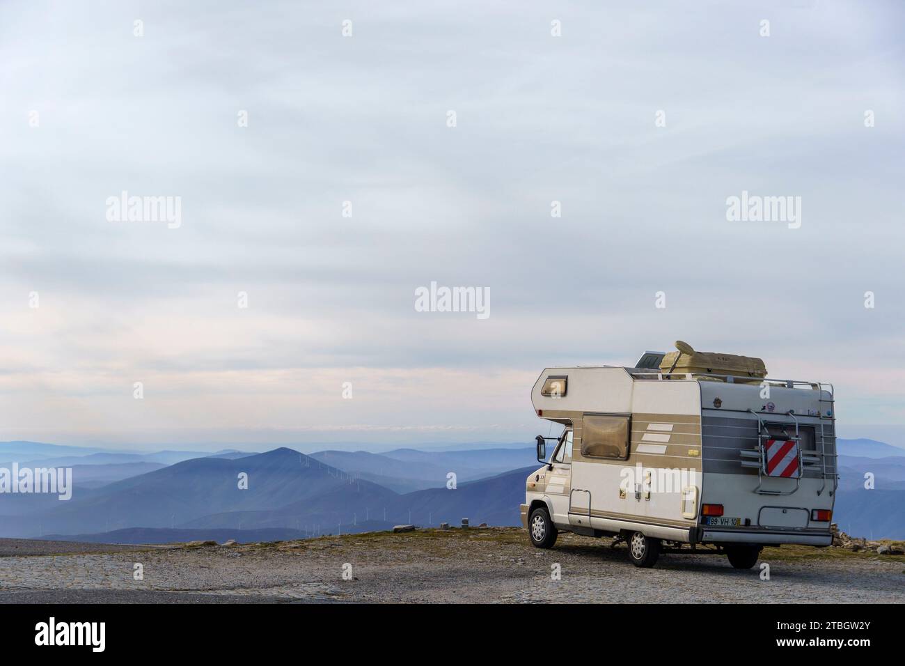 Camper parcheggiato di fronte a un paesaggio montano Foto Stock