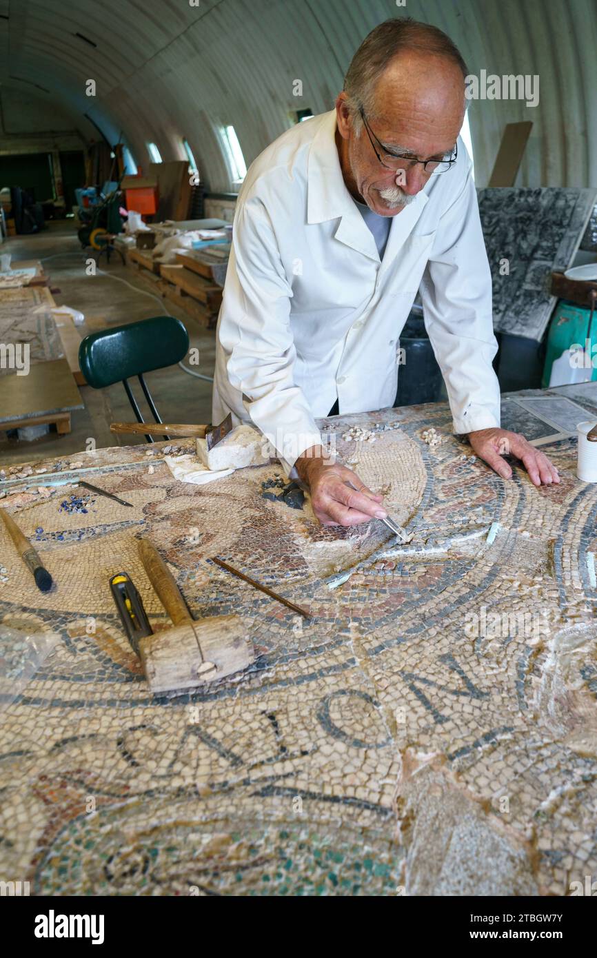 Persona che ripristina il mosaico romano a Conimbriga, Portogallo, Europa Foto Stock