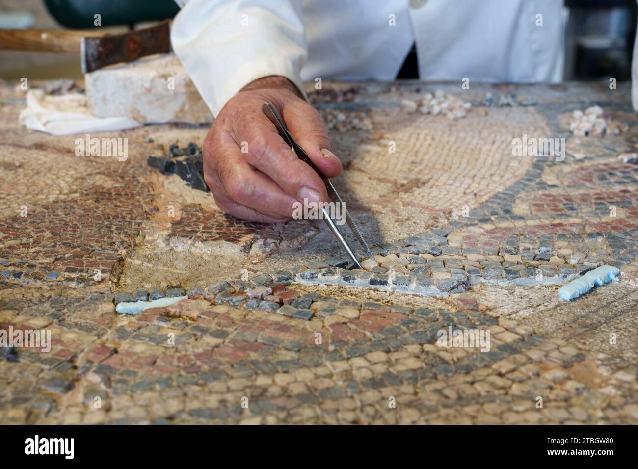 Persona che ripristina il mosaico romano a Conimbriga, Portogallo, Europa Foto Stock