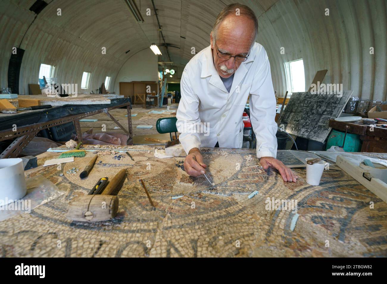 Persona che ripristina il mosaico romano a Conimbriga, Portogallo, Europa Foto Stock