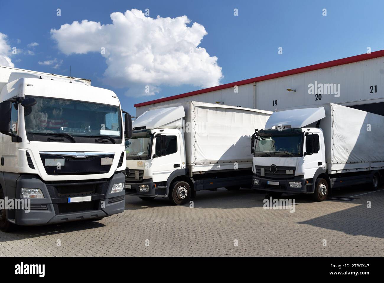 Camion che caricano ad un deposito di un'agenzia di spedizione - Trasporti e logistica nel commercio di merci Foto Stock