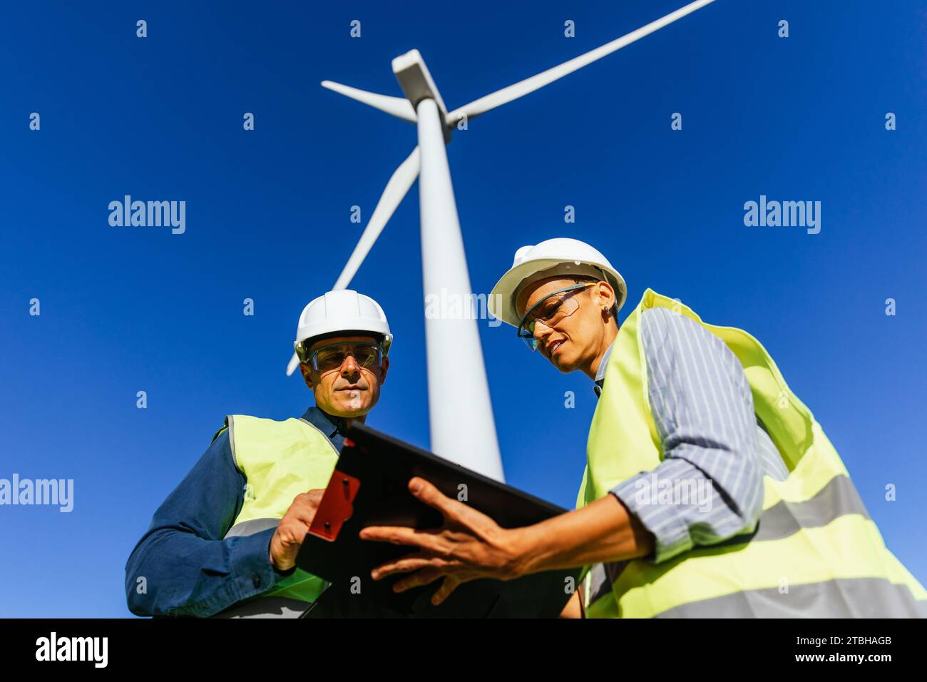 Ingegnere e lavoratore di mulini a vento che compila i documenti. Foto Stock