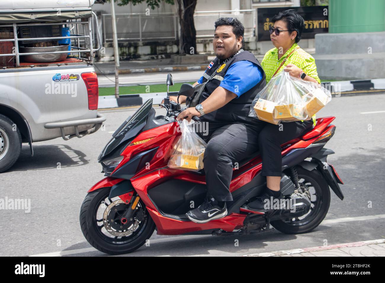 SAMUT PRAKAN, THAILANDIA, 11 ottobre 2023, una coppia trasporta un acquisto su una moto Foto Stock