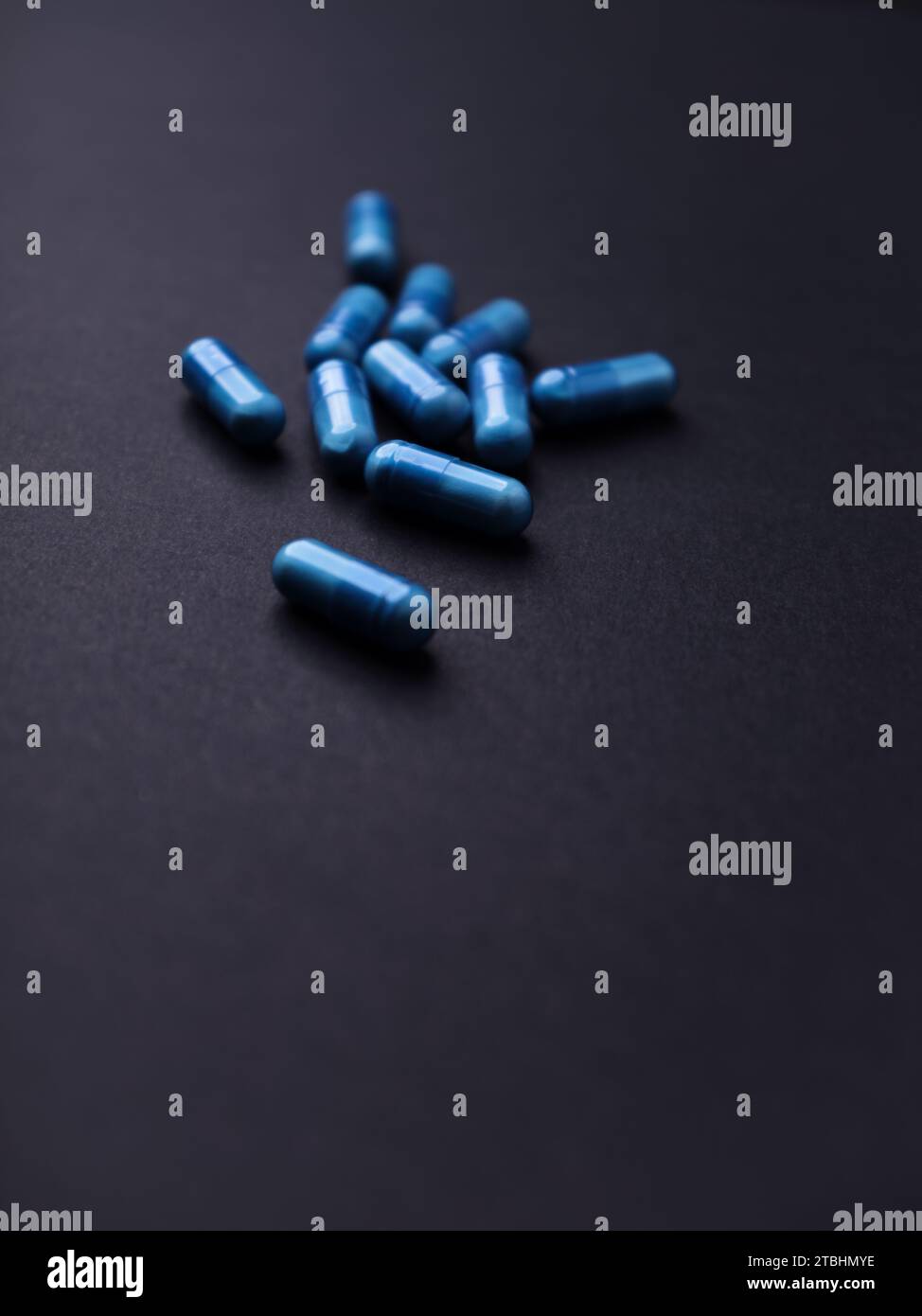 Capsule di aminoacidi su sfondo di carta scura. Messa a fuoco morbida. Primo piano. Copia spazio. Foto Stock