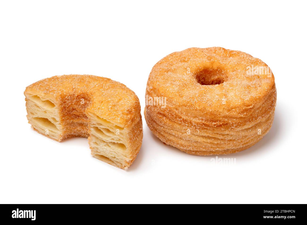 Gustosi Cronuts dolci e alla cannella, interi e tagliati a metà, isolati su fondo bianco Foto Stock