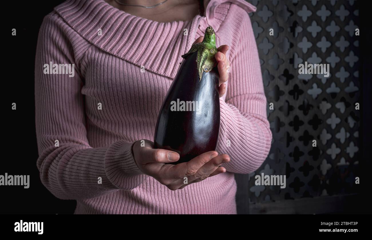 donna in possesso di melanzane o melanzane , concetto di alimentazione sana , vegetariana o vegana . Foto Stock