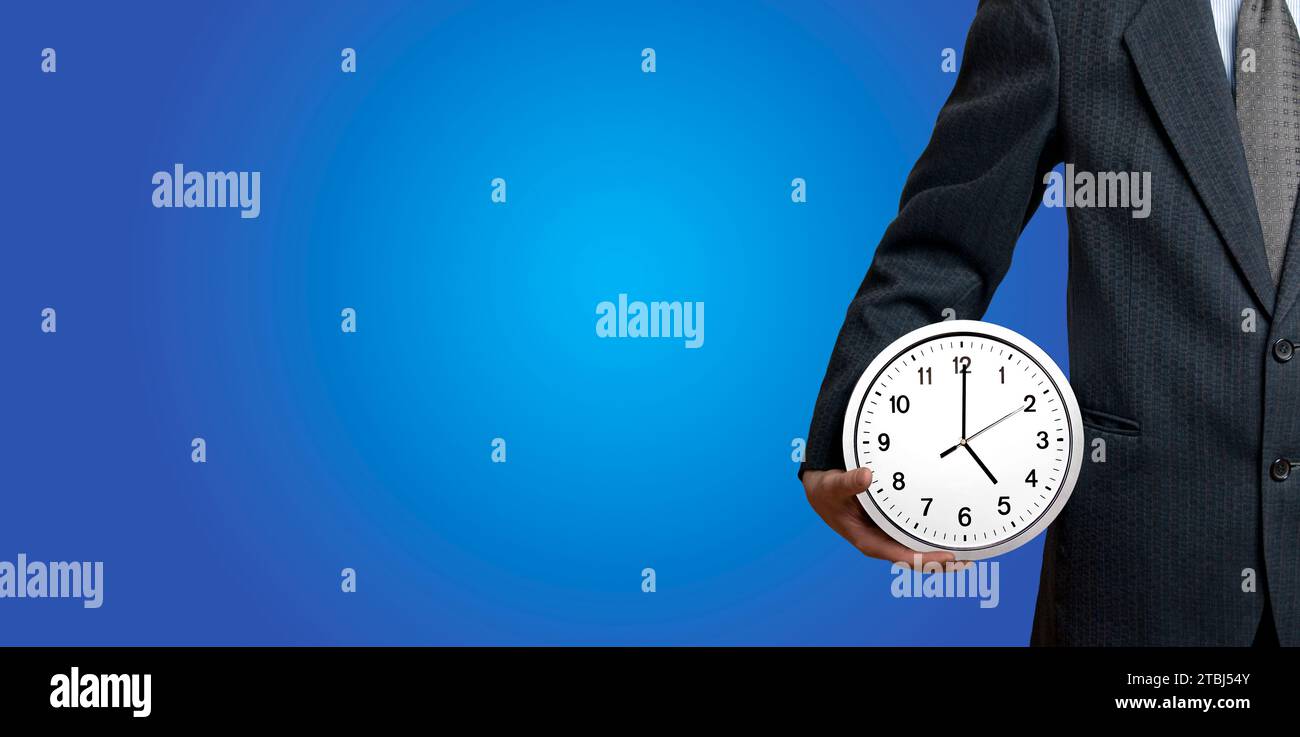 uomo d'affari che tiene un orologio, il tempo e' denaro e un concetto da 8 a 5 Foto Stock